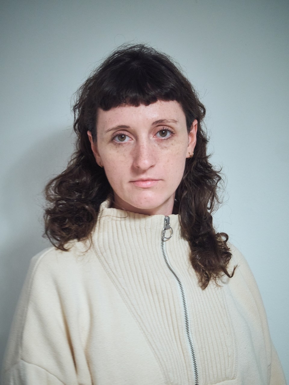 Die Kostümbildnerin blickt nachdenklich in die Kamera.