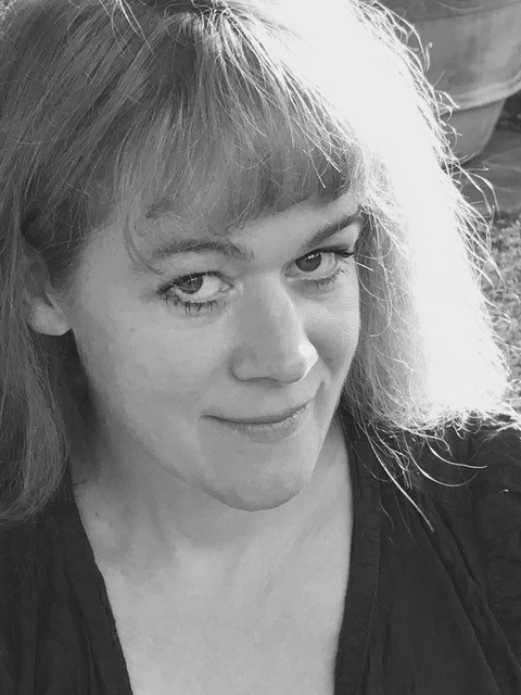 Die Regisseurin blickt schelmisch von unten in die Kamera