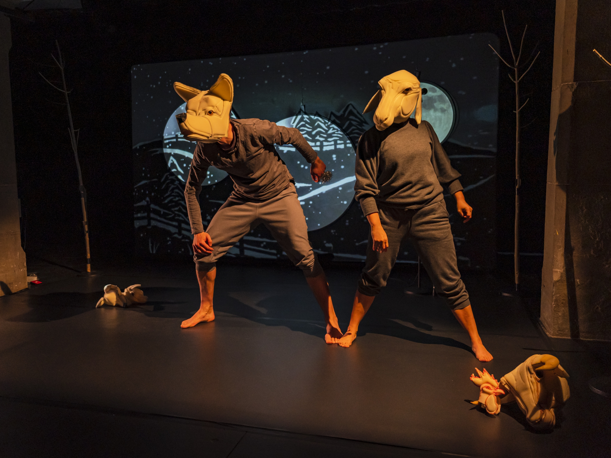 Zwei Menschen mit einer Schaf- und einer Wolfsmaske nebeneinander.