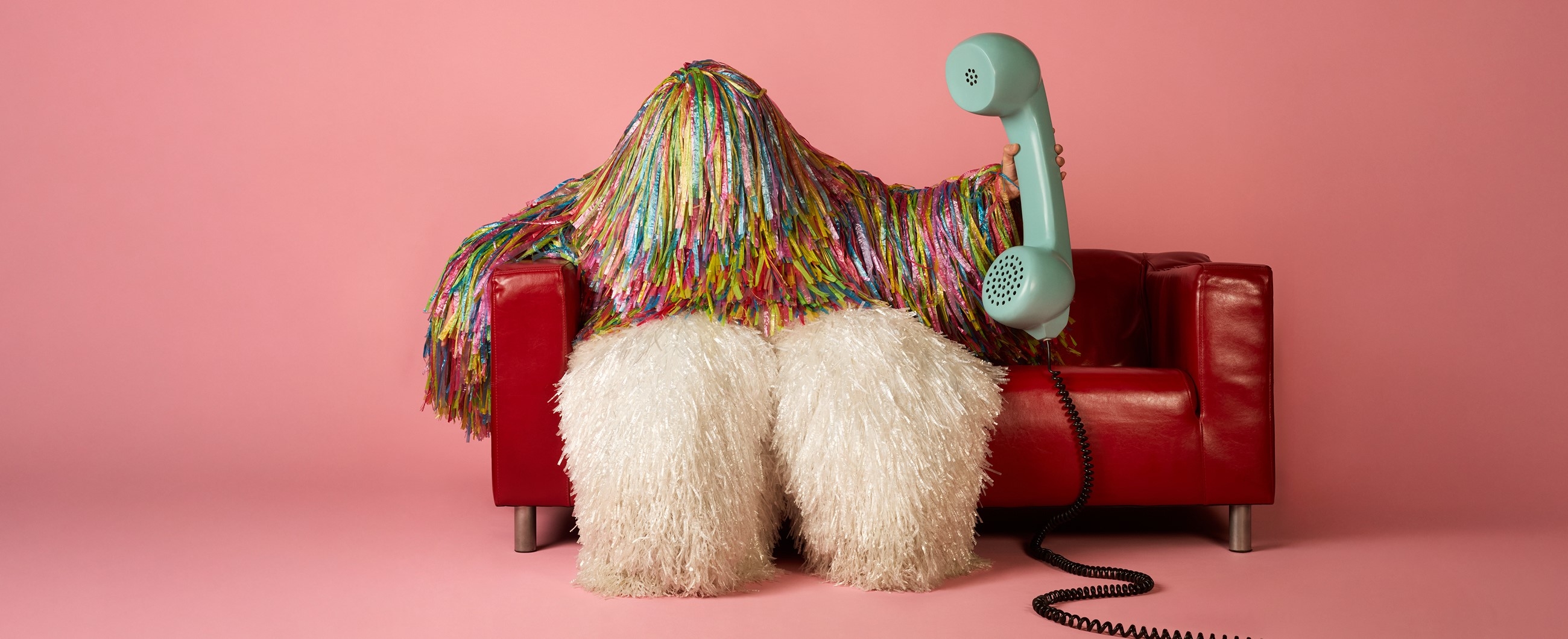 Ein Monster sitzt auf einem Sofa und hält einen grossen Telefonhörer in der Hand