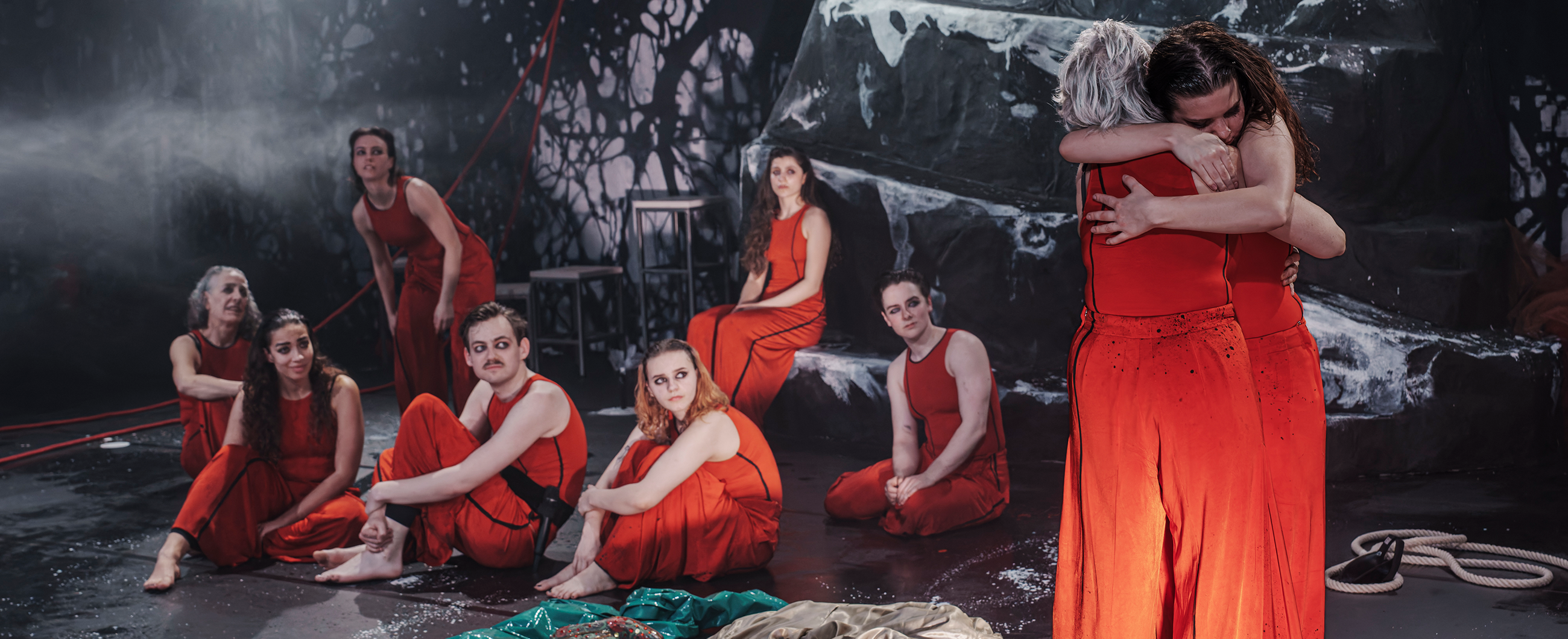 Titelbild mit sitzenden Menschen in roten Kostümen